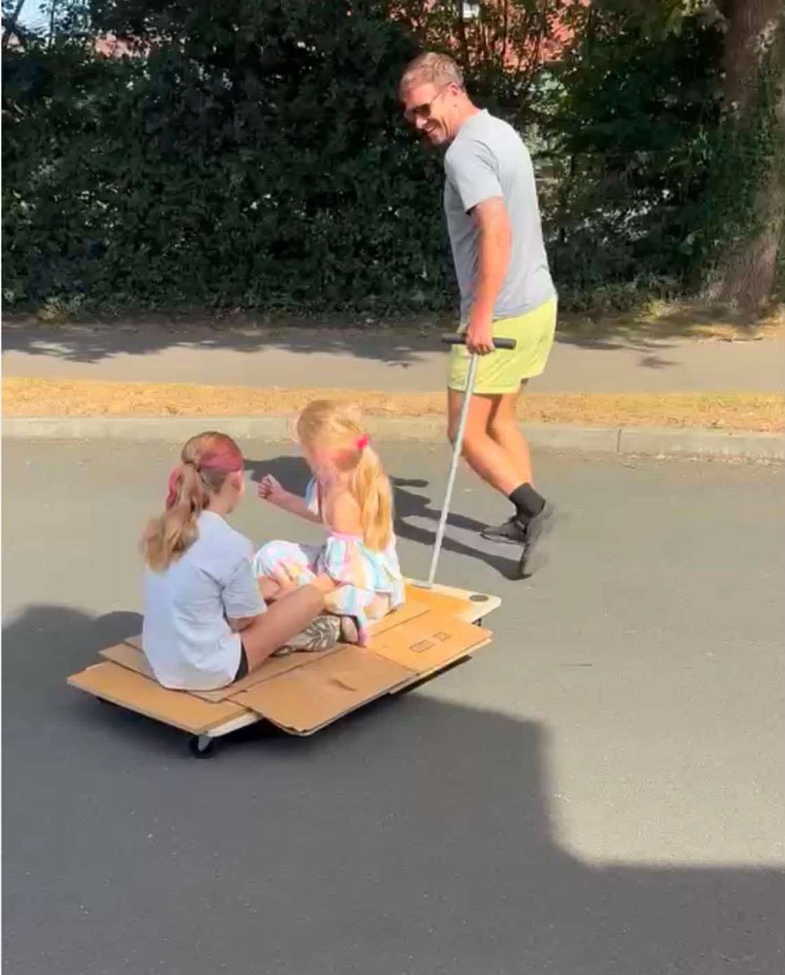 Children riding a moving skate on a Hampshire driveway during a house move